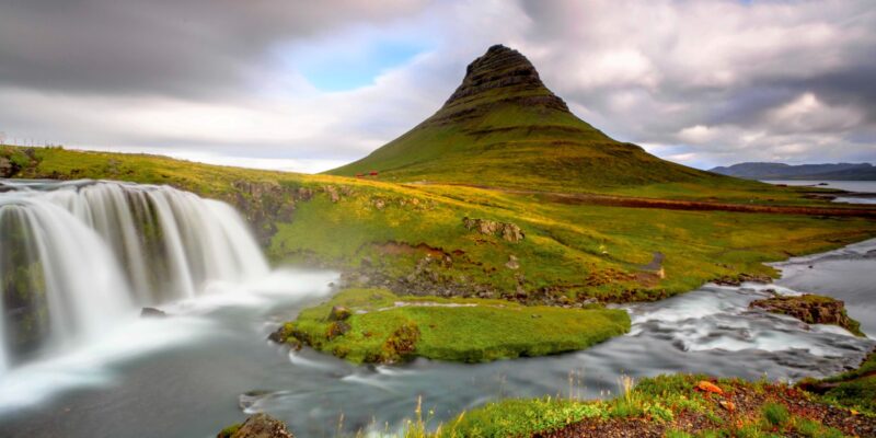 Un fiumiciattolo in primo piano e, sullo sfondo, la montagna più famosa d'Islanda con il suo bel colore verde